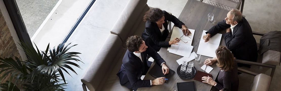 A high-angle view of a group of business professionals sitting together around a table